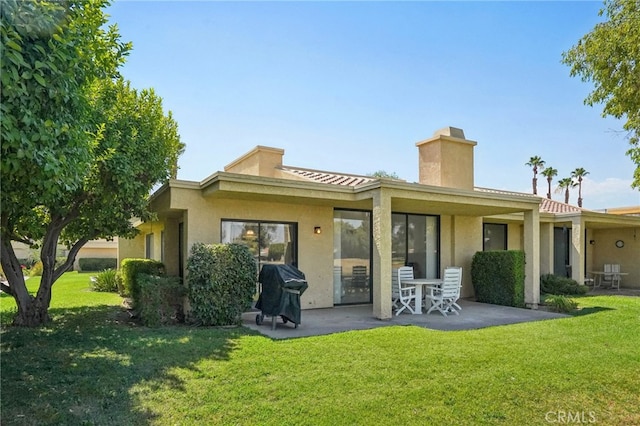 rear view of property with a patio area and a yard