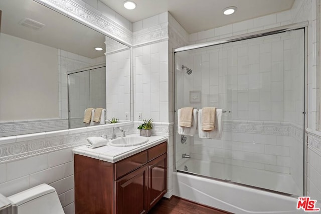 full bathroom featuring vanity, toilet, enclosed tub / shower combo, tile walls, and wood-type flooring