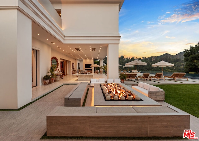 patio terrace at dusk featuring a fire pit