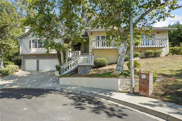 view of front facade featuring concrete driveway, stairway, an attached garage, crawl space, and stucco siding