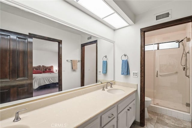 bathroom featuring tile patterned flooring, vanity, toilet, and a shower with shower door