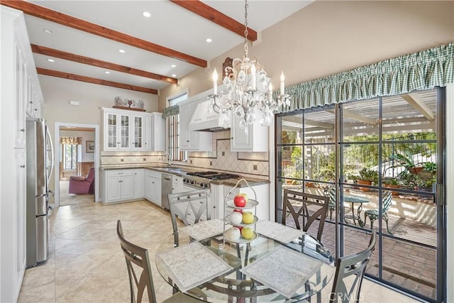 kitchen with pendant lighting, plenty of natural light, decorative backsplash, and white cabinetry