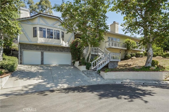 view of front property featuring an attached garage, driveway, stairs, and a chimney