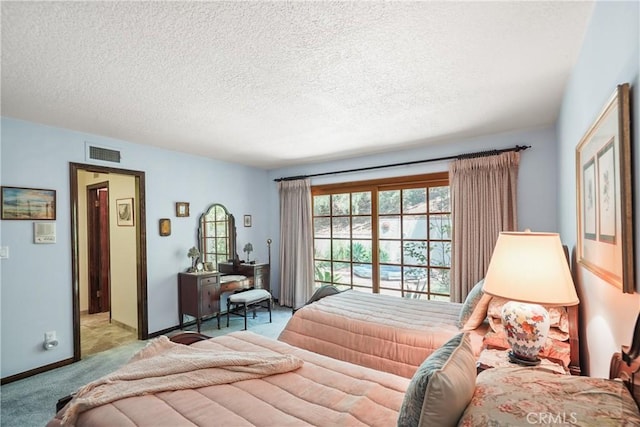 bedroom featuring a textured ceiling and light carpet