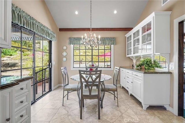 tiled dining space with an inviting chandelier and vaulted ceiling