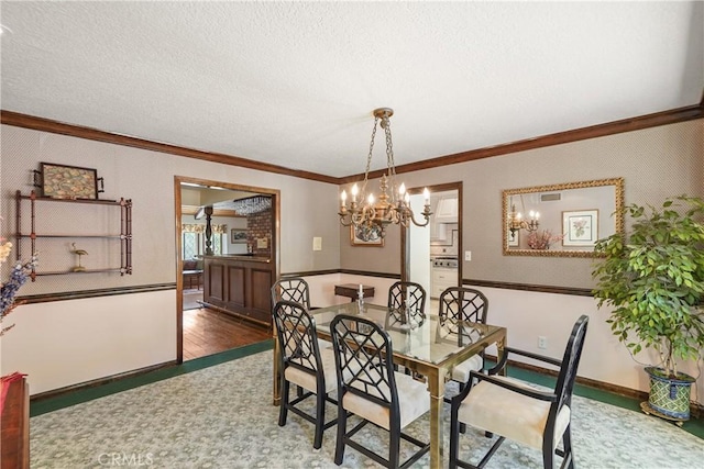 dining space featuring crown molding, dark wood-type flooring, a textured ceiling, and an inviting chandelier