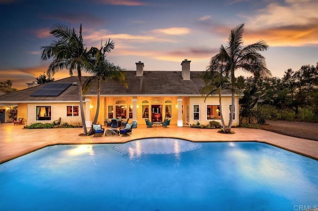 pool at dusk with a patio