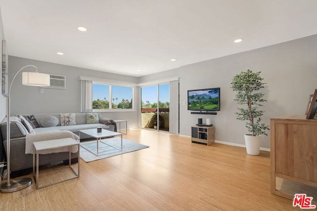 living room featuring light hardwood / wood-style flooring and a wall mounted air conditioner