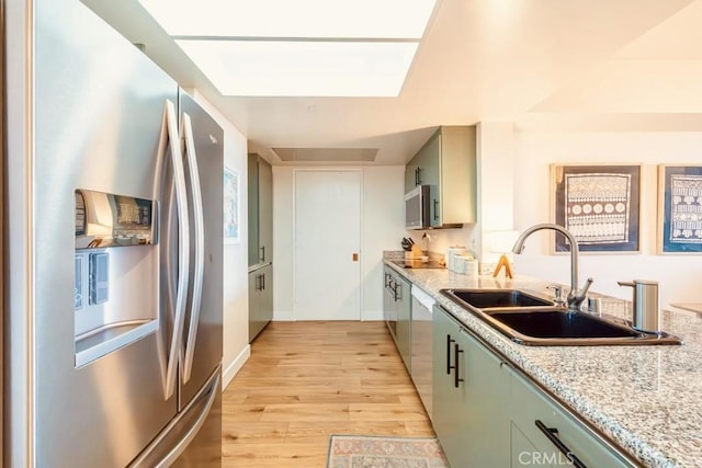 850 E Ocean Blvd Unit 613, Long Beach, CA 90802 - kitchen featuring stainless steel appliances, a sink, light wood-style flooring, green cabinets, and light stone counters