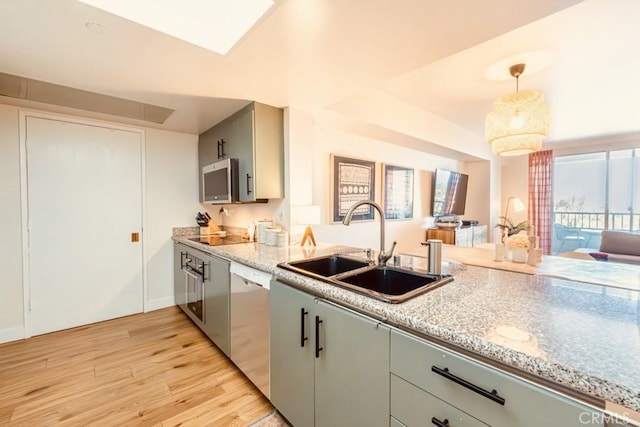 850 E Ocean Blvd Unit 613, Long Beach, CA 90802 - kitchen with stainless steel appliances, a sink, light wood finished floors, pendant lighting, and light stone counters