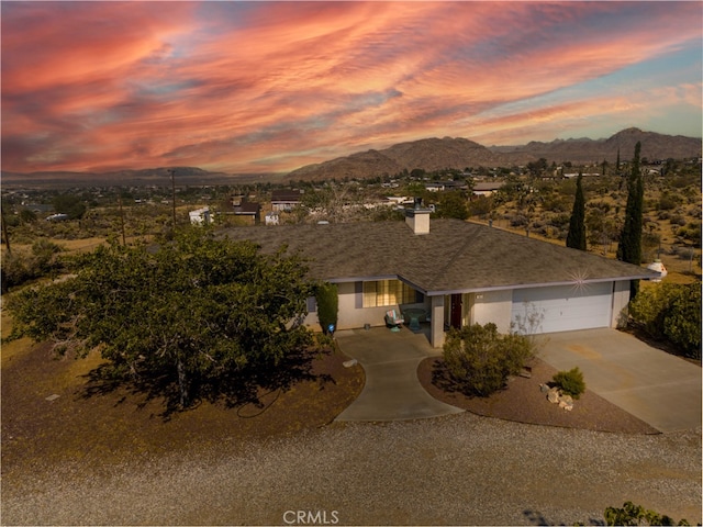 view of front of home with a mountain view and a garage