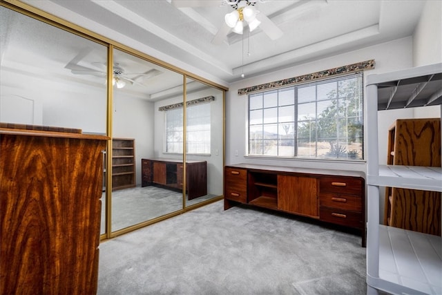 home office with a raised ceiling and light carpet