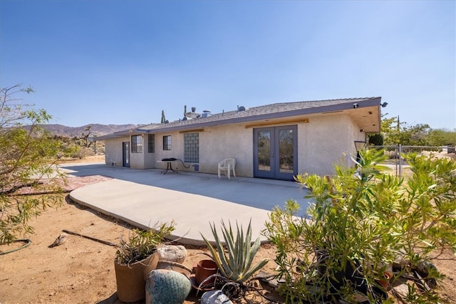 rear view of property featuring a mountain view, a patio, and french doors