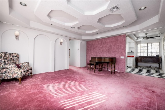 interior space featuring a tray ceiling, ceiling fan, carpet flooring, and a textured ceiling