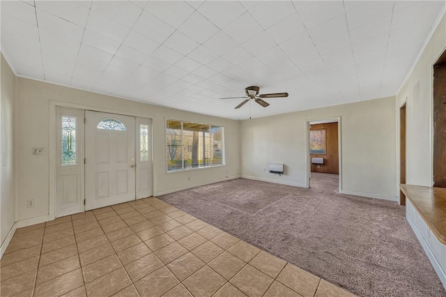 carpeted entrance foyer featuring heating unit and ceiling fan