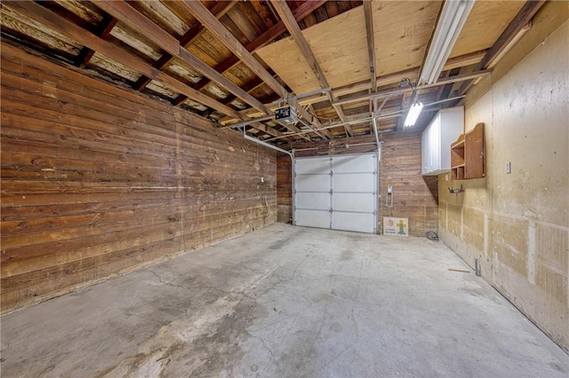 garage with wood walls and a garage door opener