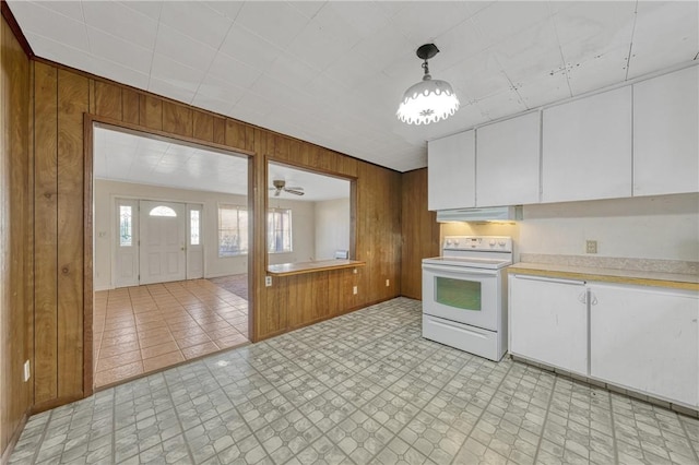 kitchen featuring ceiling fan, wooden walls, pendant lighting, white cabinets, and white electric range