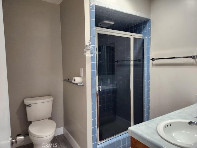 bathroom with toilet, vanity, and walk in shower