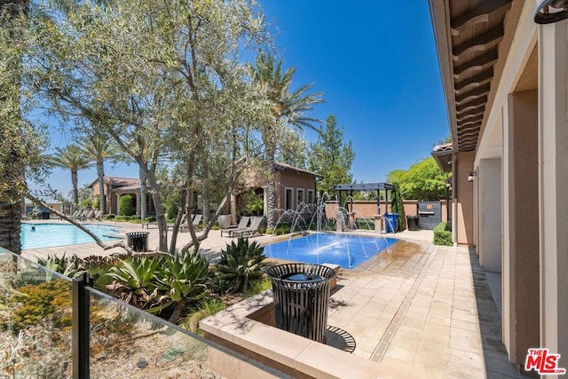 view of swimming pool with a pergola, pool water feature, and a patio