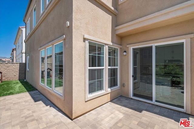 view of property exterior with a patio area