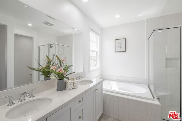 bathroom with vanity and shower with separate bathtub