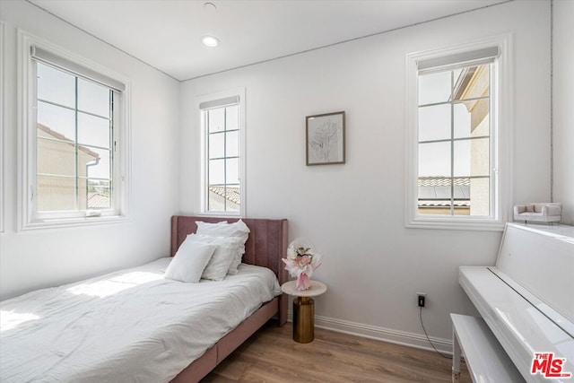 bedroom featuring dark wood-type flooring and multiple windows