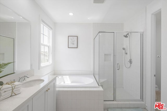 full bathroom featuring toilet, vanity, and separate shower and tub