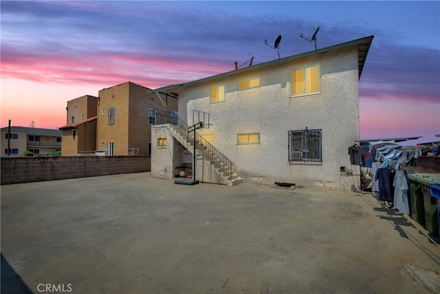 back house at dusk with a patio area