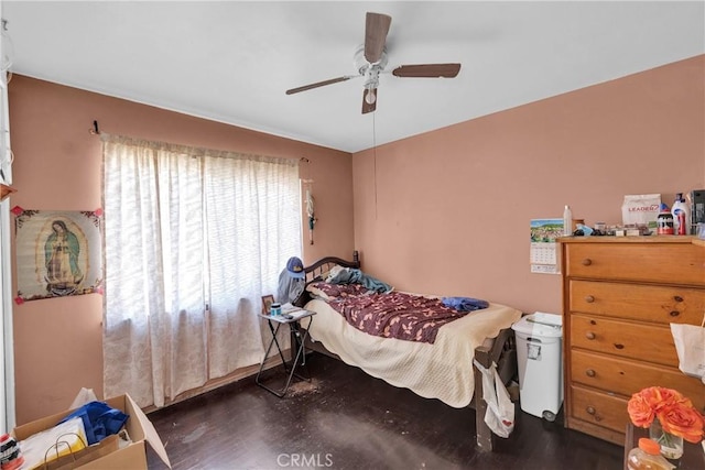 bedroom with dark hardwood / wood-style flooring and ceiling fan