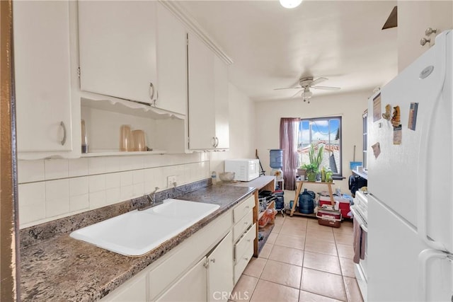 kitchen with decorative backsplash, white appliances, ceiling fan, sink, and white cabinetry