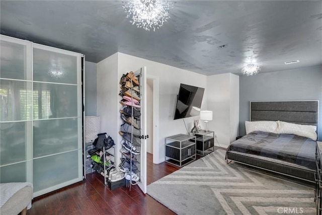 bedroom featuring dark hardwood / wood-style flooring and a notable chandelier