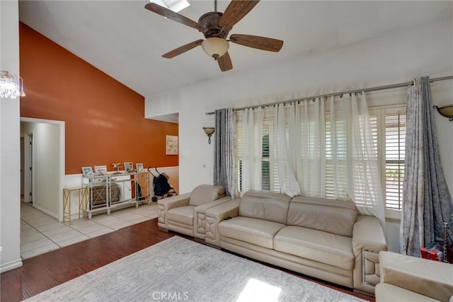 living room with light wood-type flooring, a wealth of natural light, lofted ceiling, and ceiling fan