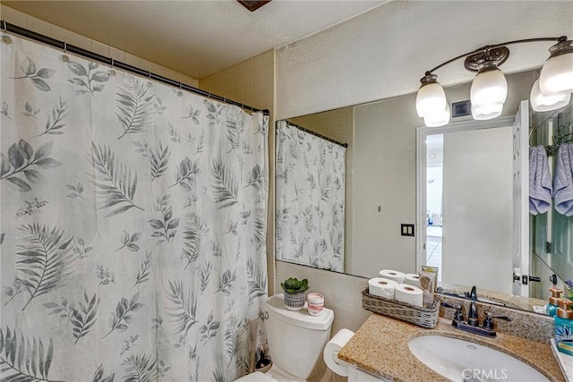 bathroom featuring toilet, vanity, and walk in shower