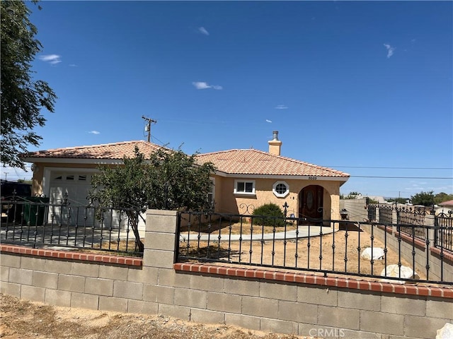 view of front facade featuring a tile roof, a fenced front yard, a chimney, an attached garage, and stucco siding