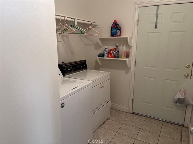 laundry room with washing machine and clothes dryer, baseboards, laundry area, and light tile patterned flooring