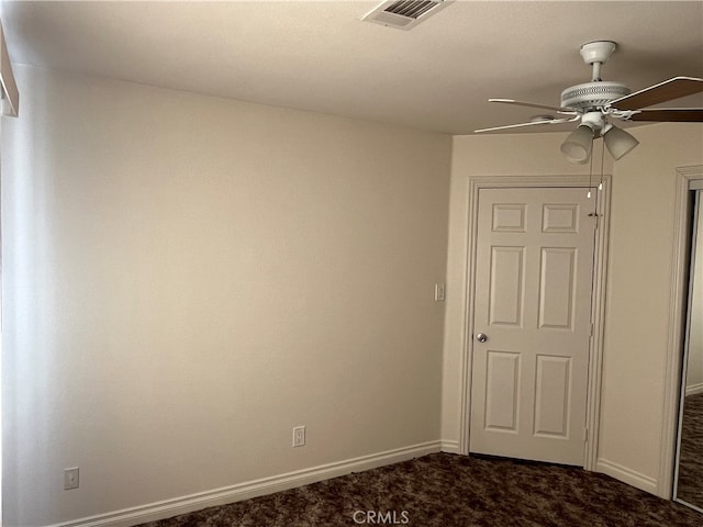 unfurnished room with dark carpet and ceiling fan