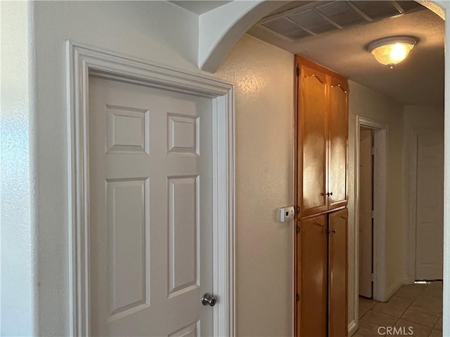 hall featuring arched walkways, visible vents, and light tile patterned floors
