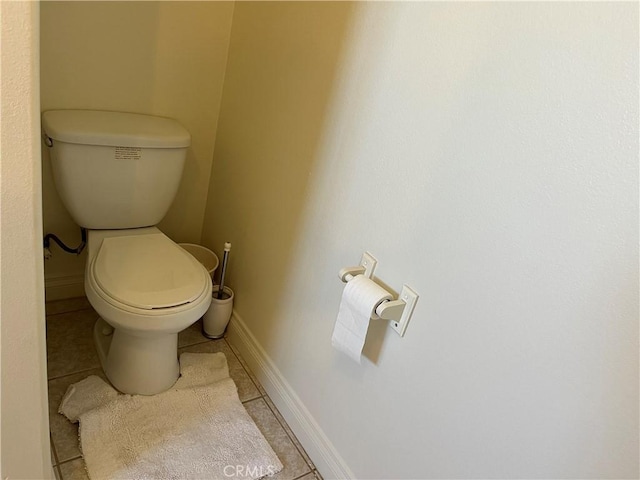 bathroom with tile patterned floors, baseboards, and toilet