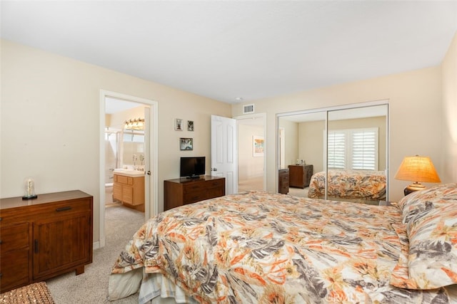 carpeted bedroom featuring connected bathroom and a closet