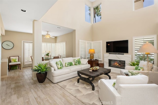 5564 Spinnaker Bay Dr, Long Beach, CA 90803 - living area featuring wood finished floors, a ceiling fan, a high end fireplace, a high ceiling, and baseboards