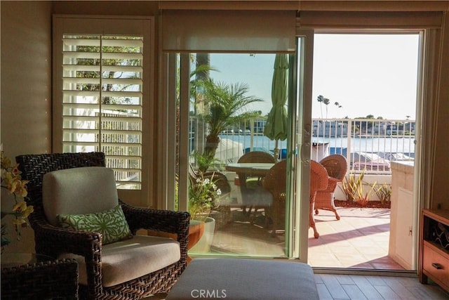 doorway to outside with hardwood / wood-style flooring and a water view