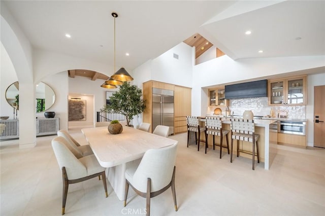 tiled dining room with high vaulted ceiling