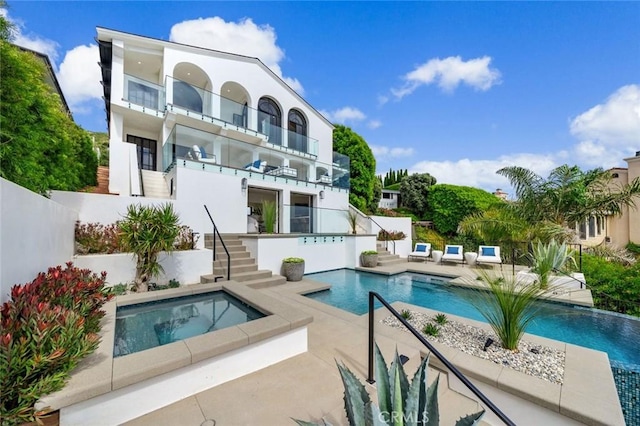 view of swimming pool with a patio area and an in ground hot tub