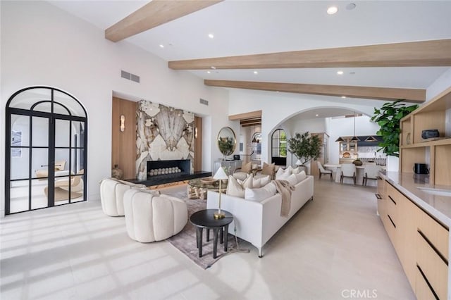 living room featuring beamed ceiling and high vaulted ceiling