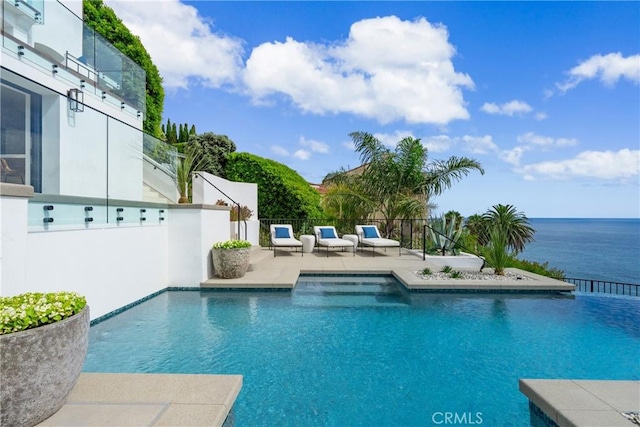 view of swimming pool featuring a water view and a patio