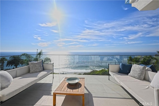 balcony featuring an outdoor living space and a water view