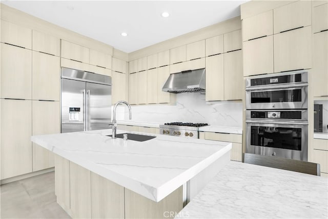 kitchen featuring tasteful backsplash, sink, range hood, an island with sink, and appliances with stainless steel finishes