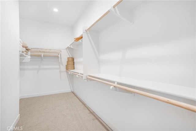 walk in closet featuring light carpet