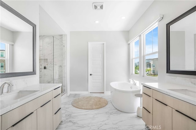 bathroom featuring vanity, separate shower and tub, and a wealth of natural light