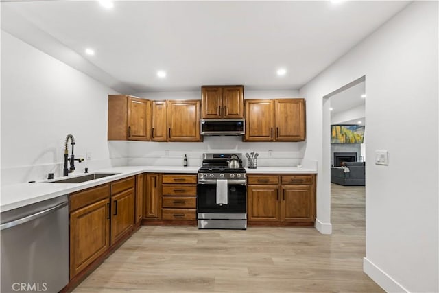 310 Whittley Ave Unit A, Avalon, CA 90704 - kitchen with light wood-style floors, a sink, brown cabinetry, and appliances with stainless steel finishes